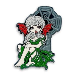 Cemetery Mist enamel pin has a white haired fairy with red wings sitting in front of a Celtic cross